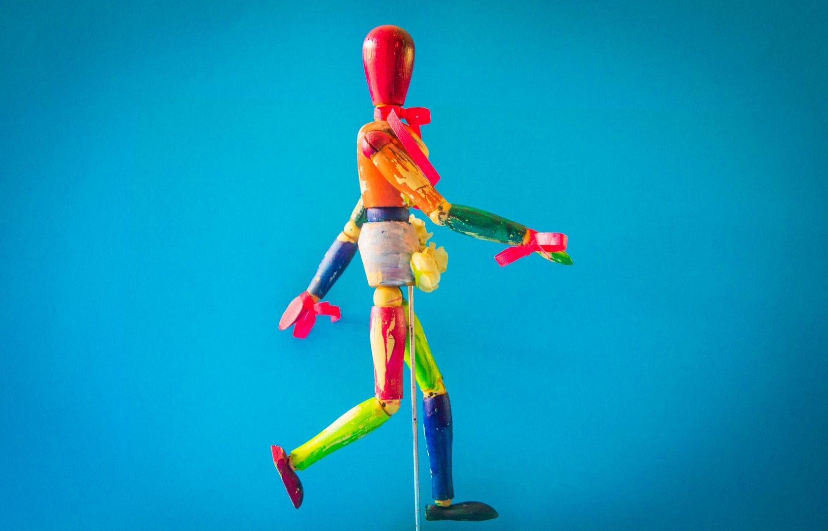Färgglad stop motion-docka med ledad armatur mot blå bakgrund
